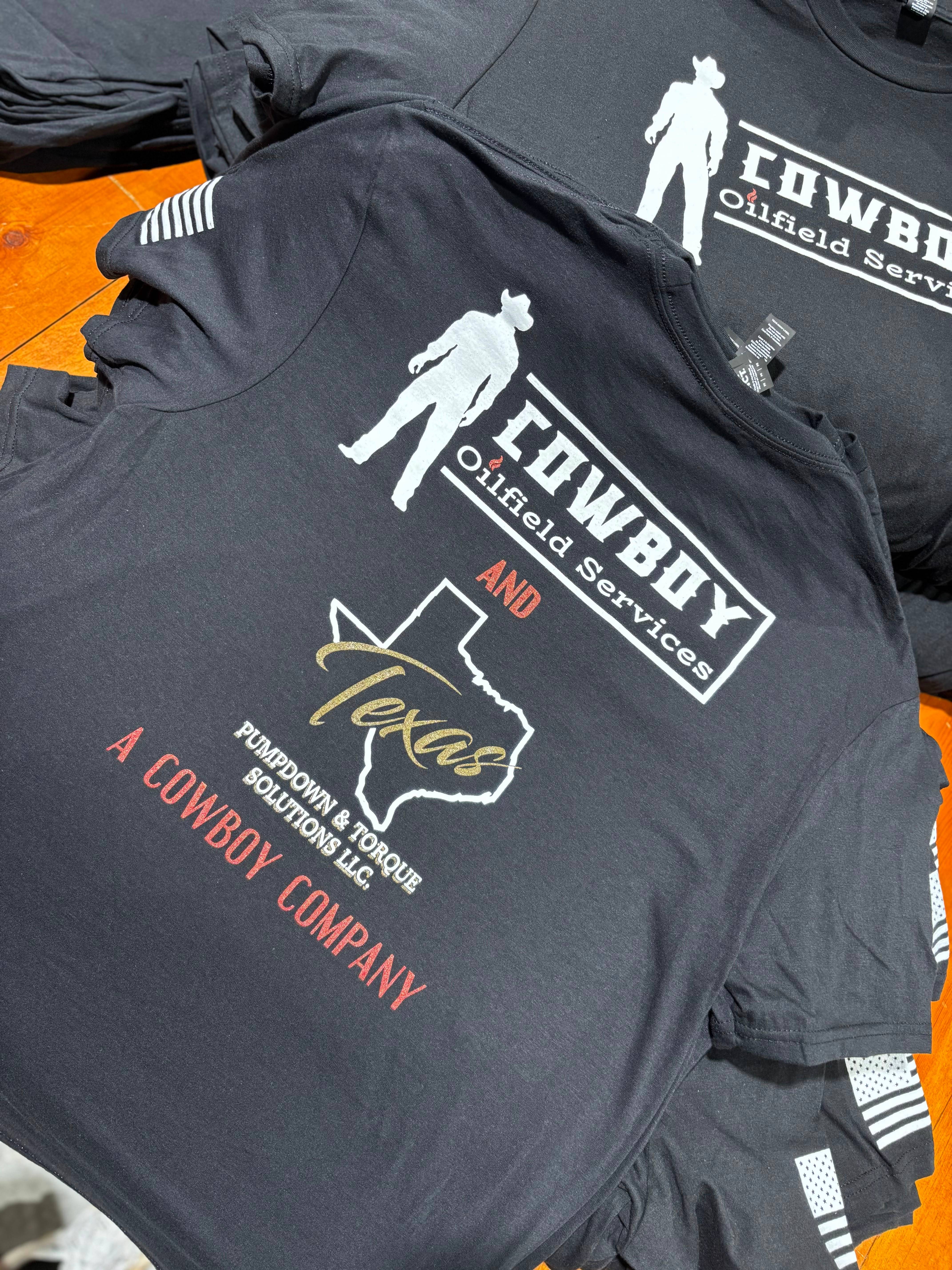 Black screen-printed Cowboy Oilfield Services t-shirts with logo folded and stacked