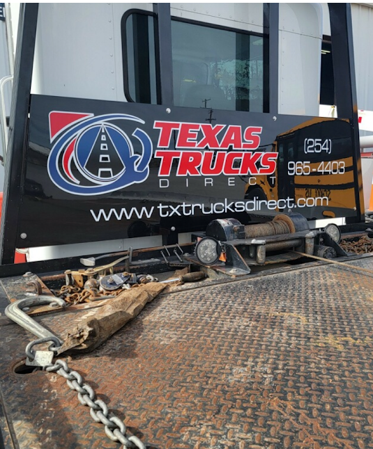 Texas Trucks Direct logo and phone number vinyl decal installed on a flatbed work truck